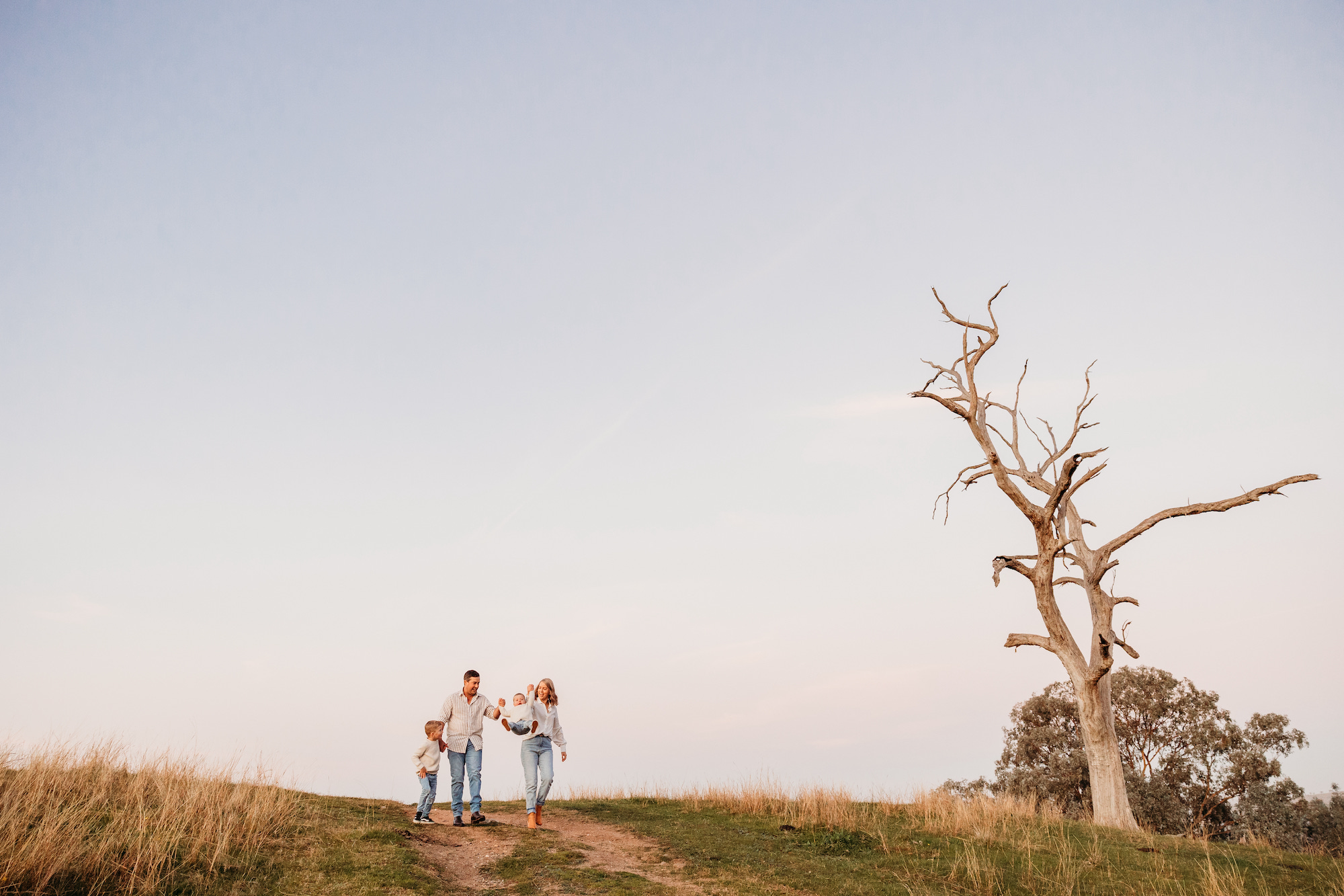 mum-and-dad-swinging-kids-in-air-at-family-photography-albury-photoshoot
